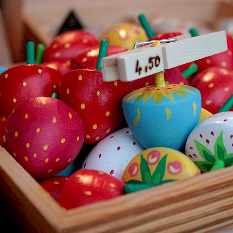 Bunte Erdbeeren aus Holz, eine beschriftete Wäscheklammer verweist auf den Preis von 4,50 Euro