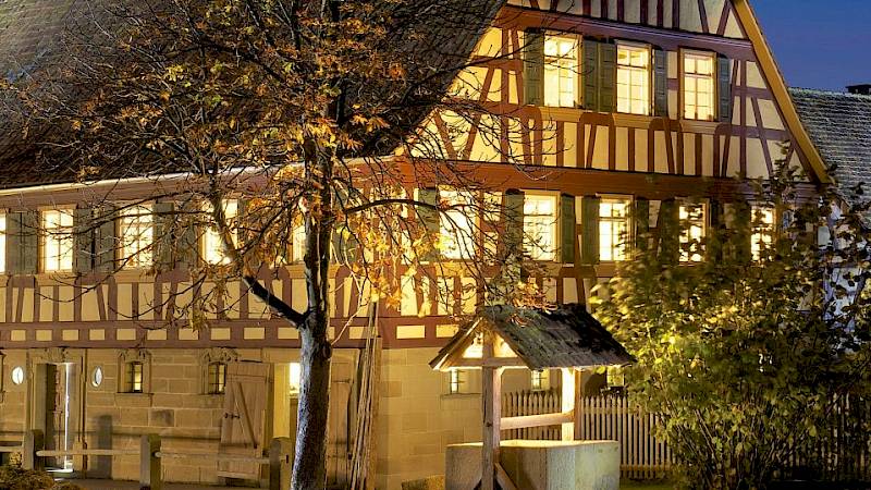 Fachwerkhaus bei Nacht mit erleuchteten Fenstern