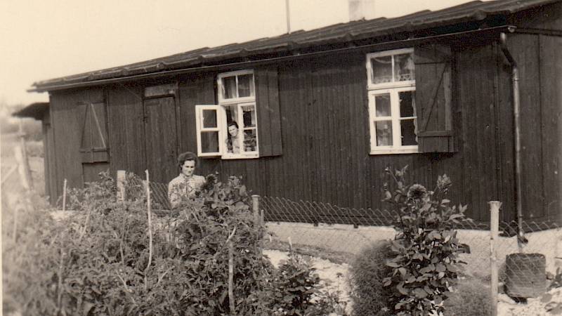 Historische Schwarz-Weiß- Fototgrafie von Zwangsarbeitern beim Graben, welche von zwei bewaffneten Soldaten bewacht werden